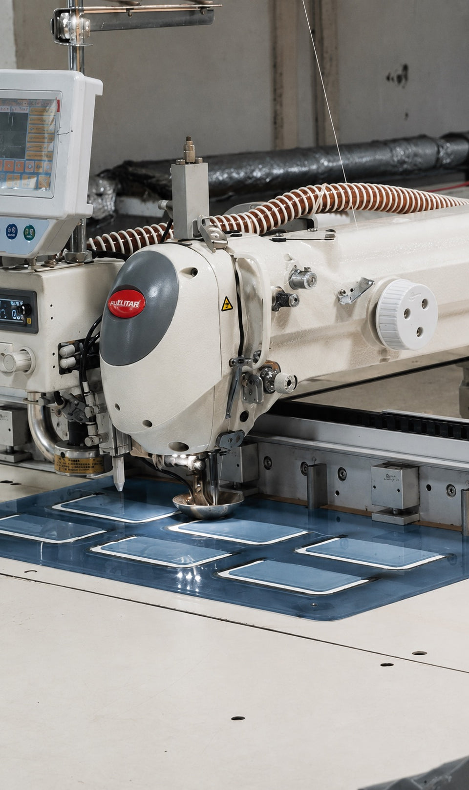 Close-up of sewing equipment and a blue work fixture in the YJ factory